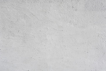 The texture of the wall is plastered rough, white