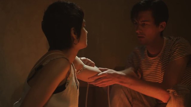  Drug addict couple in gloomy apartment, man injecting girlfriend in the arm