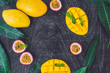 Mango and passion fruit on an old wooden background. Copy space