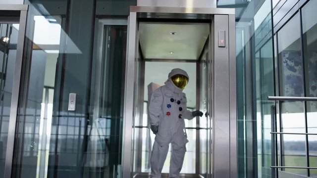  Astronaut taking the elevator in modern office building