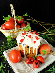 Easter cake surrounded by coloured eggs and spring green. Easter cake is decorated with glazing and confectionery