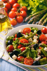 Vegetable salad with asparagus, tomatoes, feta cheese and olives.