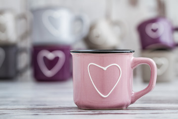 Colorful Cute Coffee Mugs with Hearts on White Wooden Background