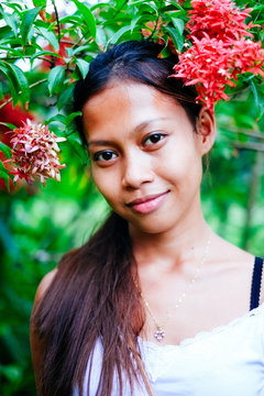Beautiful assian gilr in the garden with flowers
