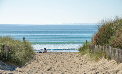 Fototapeta na wymiar vacancier assis au bord la mer dans le sable