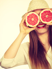 Woman holds two halfs of grapefruit citrus fruit in hands