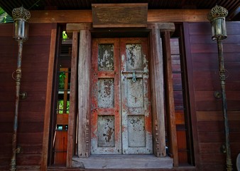   Old brown wooden door with wrought iron in need renovation 