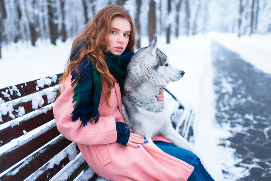 Woman sitting on the bench with siberian husky