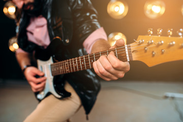 Obraz na płótnie Canvas Male rock star with electro guitar on the stage