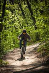 man ride mountain bike through forest