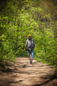 man ride mountain bike through forest