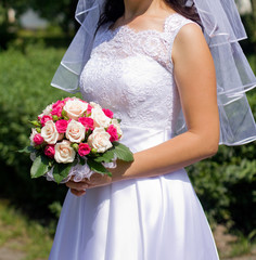 Bride holding wedding bouquet with roses