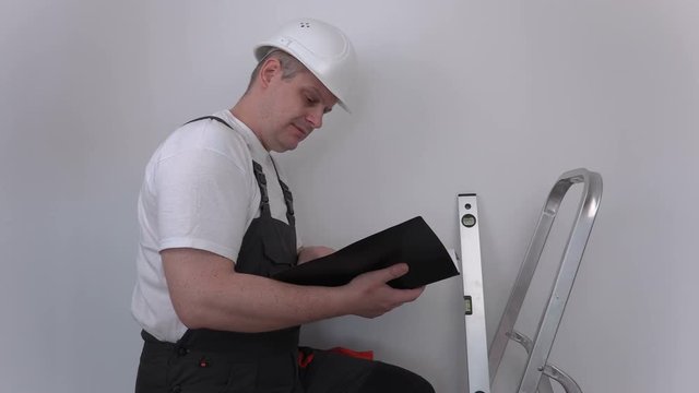 Builder reading and show thumb up near stairs
