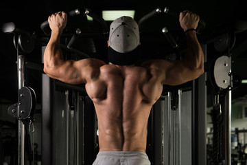 Fototapeta na wymiar Male Bodybuilding Athlete Doing Pull Ups