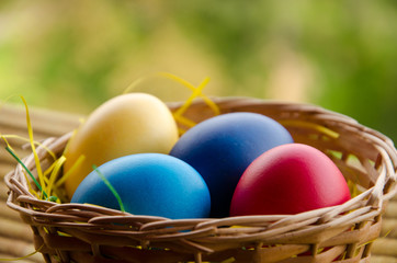 Colourful Easter Eggs in basket with bokeh background