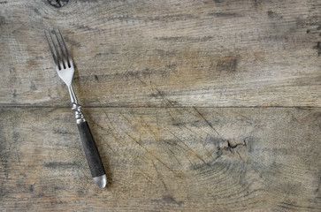 Old fork on wooden background