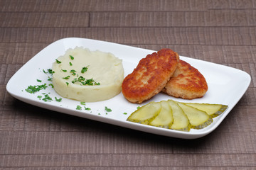 cutlet with mashed potato and pickled cucumber