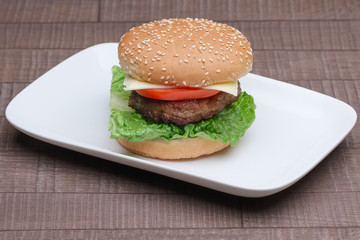 fresh tasty burger on plate on wooden table
