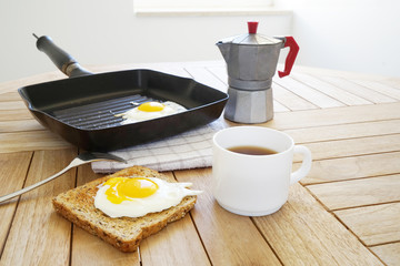 Fried eggs with toast and coffee on the wooden table