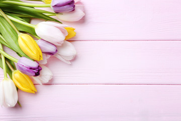 Bouquet of tulips on pink wooden table