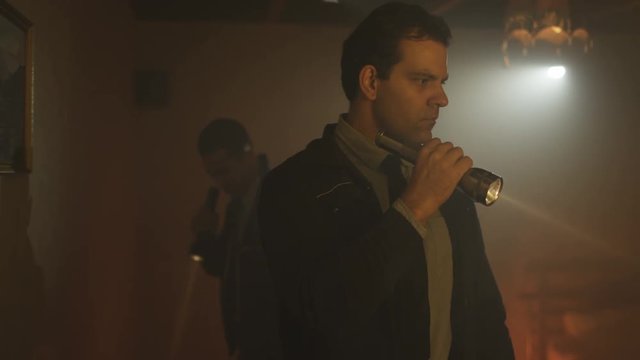  Portrait of tough guy cop investigating crime scene with his partner