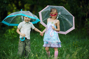 happy children under umbrella in park