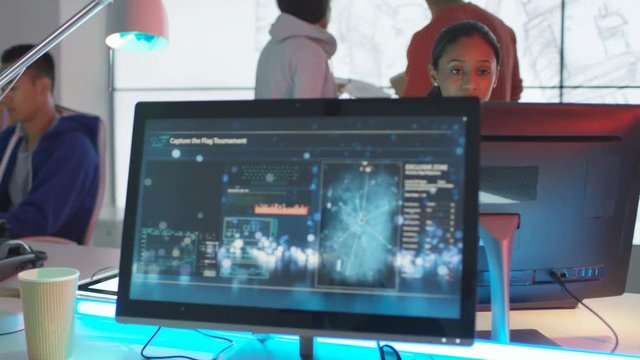  Young game designers looking at computer screens & sharing ideas