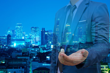 double exposure of business man with welcome hand and night modern city building background