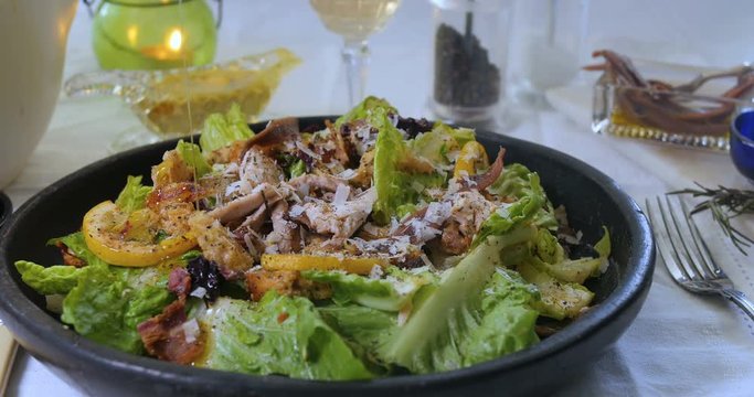 Pouring olive oil over a delicious Caesar's salad