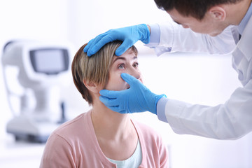 Ophthalmologist examining eyes of mature woman in clinic