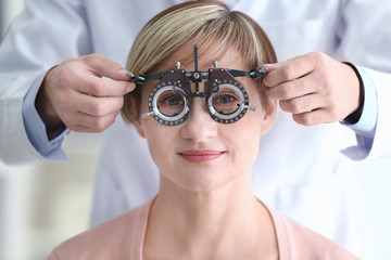 Ophthalmologist examining eyes of mature woman in clinic, closeup
