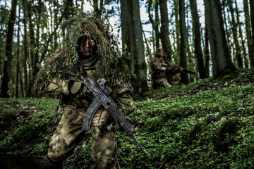 Camouflaged soldier in forest