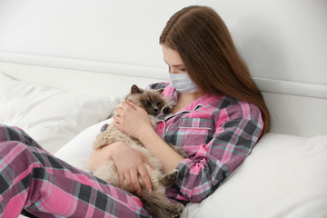 Animal allergy concept. Beautiful woman with cat in bed