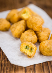 Wooden table with Chili Cheese Nuggets (selective focus)