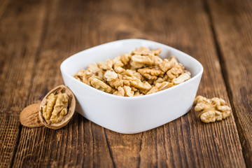 Portion of Cracked Walnuts on wooden background (selective focus)