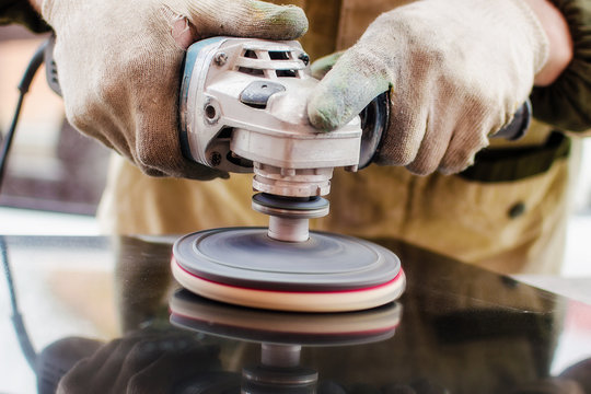 Worker polishes a stone with a grinder