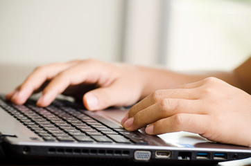 Hand typing on keyboard laptop
