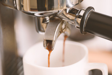 Coffee flowing into a cup from espresso machine