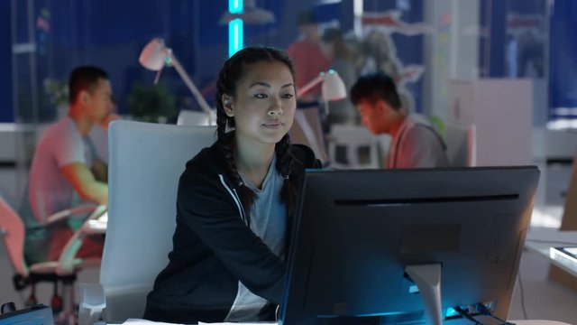 Portrait smiling computer game designer working at her desk