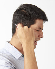 Fototapeta premium Man cleaning ear using cotton stick cause pain.