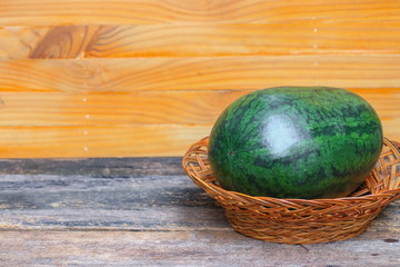 watermelon green fresh in  bamboo weave on a brown wooden background select focus with shallow depth of field.