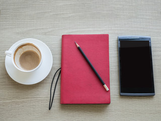 A cup of coffee with notebook and tablet on table