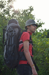 Young man with backpack on back ready to start journey