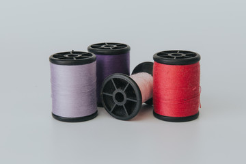 Thread bobbin on white background with vintage filter.