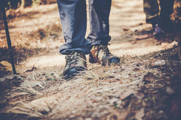 Close up of adventure man feet walk on a mountain path.