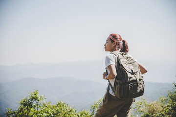 Woman traveler with backpack on beautiful summer landscape.