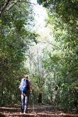 Obraz premium Adventure young man hiking in the mountains with a backpack.