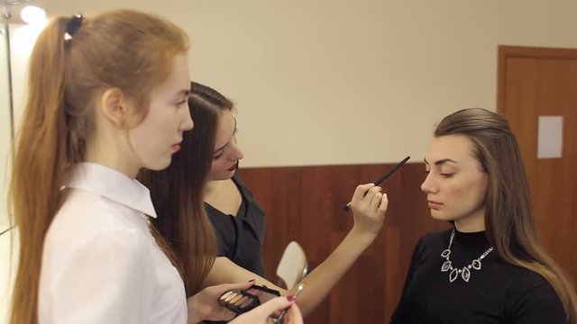 Professional make-up artist teaches the techniques of make-up on a masterclass.