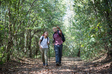 Naklejka na ściany i meble Young attractive couple hiking in the forest.