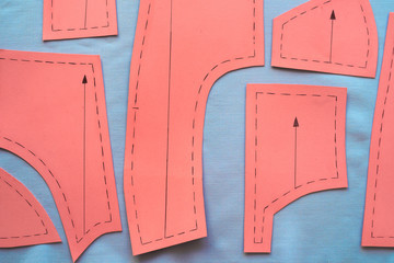 Sewing pattern on fabrics ready to cut surrounded with tailor's tools